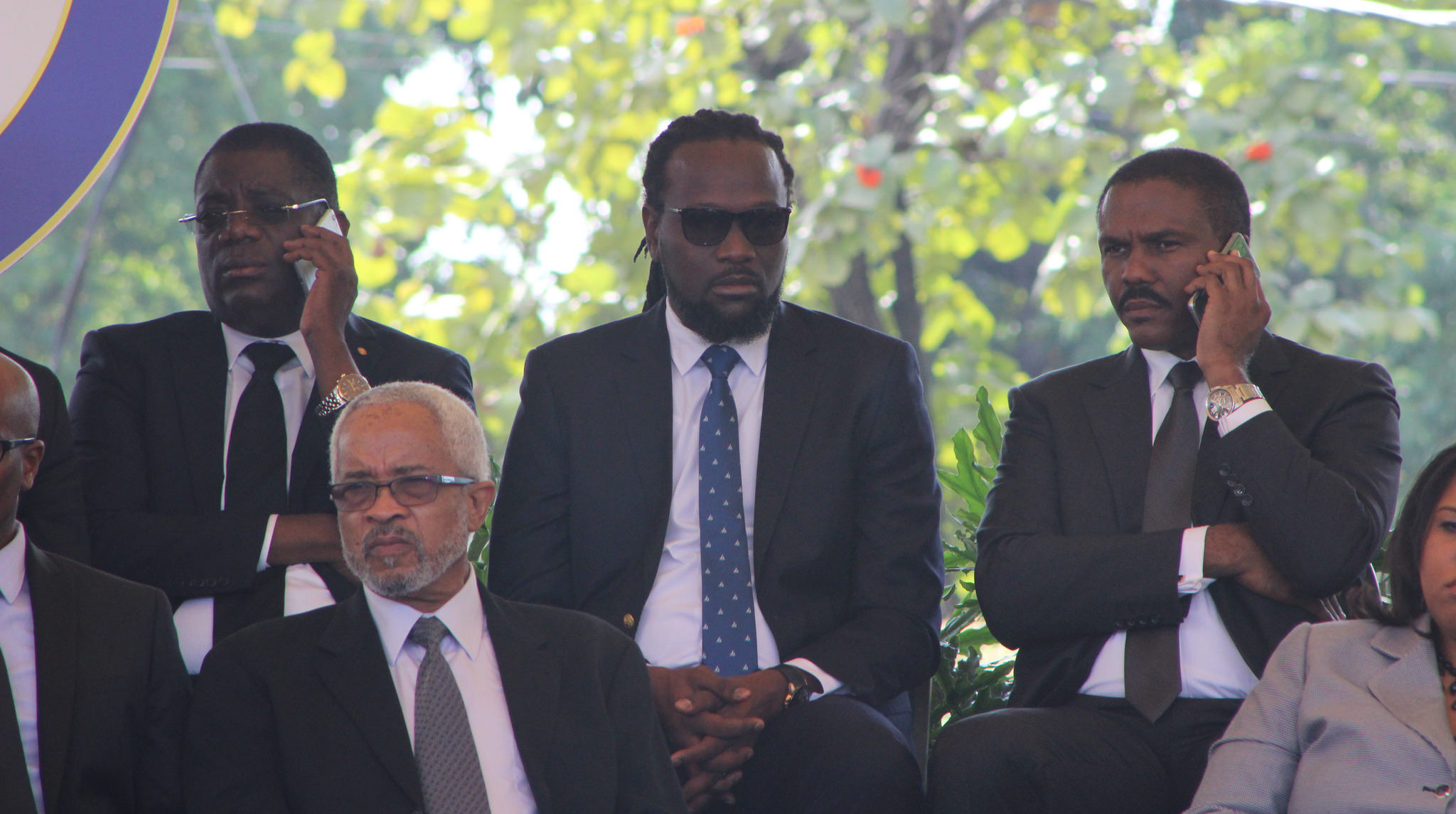 De gauche à droite, l'ancien président du Sénat RonaldLareche, sénateur et musicien Antonio "Don Kato" Cheramy, et l'ancien candidat à la présidence Jude Celestin, au téléphone. PHOTO: Daniel Tercier/Haïti Liberté