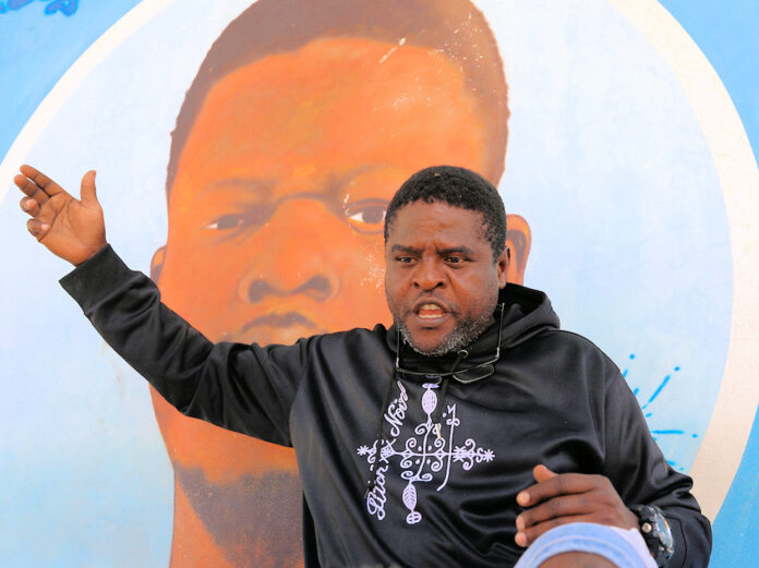 Jimmy Barbecue Cherizier in front of a mural photo Odelyn Joseph NPR Photo
